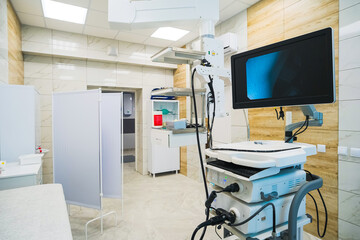 A modern medical treatment room or operating room equipped with medical equipment with a screen.