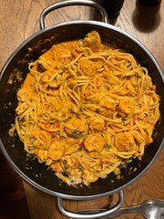 Creamy shrimp Alfredo fettuccine pasta garnished with fresh thyme, parmesan cheese, garlic, olive oil, and a sprinkle of peppercorns.