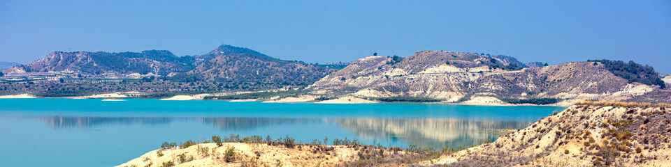 Mountain lake on a sunny day. Embalse de la Pedrera Reservoir, Alicante, Spain