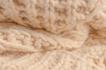 A fragment of beige knitted fabric, knitted from white sheep wool.