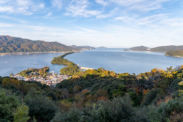 Scenic view of coastal village and hills during daytime near the water
