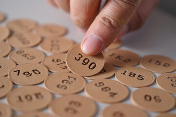 Finger holding number 390: idea, choice, luck, business, opportunity, mathematics, probability, countdown, discount, raffle, strategy, count