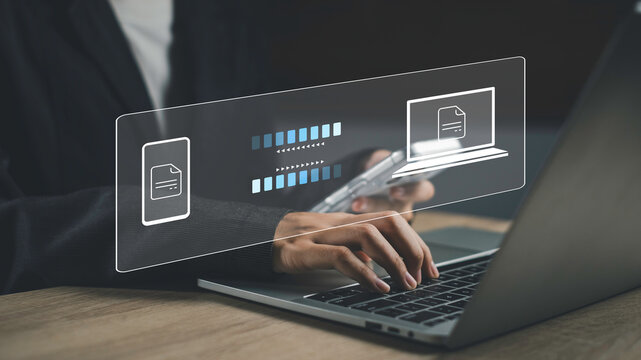 Businessman use laptop and smartphone with digital file transfer interface, representing secure file sharing, cloud-based data exchange, and fast document transmission in modern digital environments.