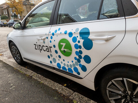 London. UK- December 06. 2025. A car parked on a suburban street with the logo and name sign of the American car sharing company Zipcar on the side of the vehicle.