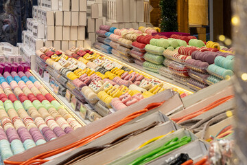 A variety of macarons are displayed in an array of pastel colors at a stand
