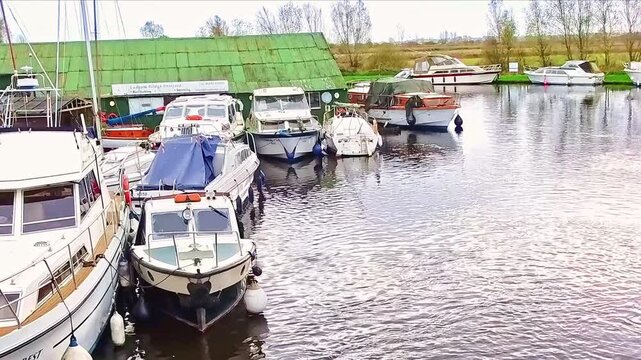 Hire boats, leisure boats and pleasure boats tied up and moored for the winter. Captured on the River Bure at Acle Bridge in the heart of the Norfolk Broads