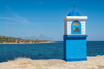 A chapel on the seashore on the Sithonia peninsula in Greece with the holy Mount Athos in the background.