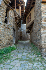 A narrow stone street between old, historic houses in the village of Kovachevitsa in the Rhodope Mountains, Bulgaria
