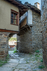 A narrow stone street between old, historic houses in the village of Kovachevitsa in the Rhodope Mountains, Bulgaria