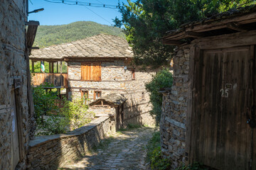 A narrow stone street between old, historic houses in the village of Kovachevitsa in the Rhodope Mountains, Bulgaria