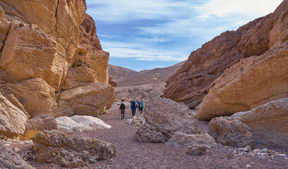 Unique landscape in Eilat Mountains nature reserve, the southern Negev, as seen from the Israel Trail passes through the reserve. A group of hikers in a hiking trail. Active lifestyle. A weekend hike.