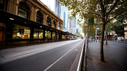 Fototapeta premium A tranquil city street scene reveals a heritage building, sleek modern skyscrapers, and a glimpse of public transport on a quiet day in the urban landscape.