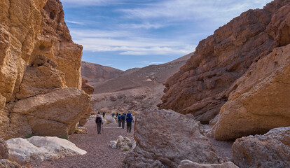Unique landscape in Eilat Mountains nature reserve, the southern Negev, as seen from the Israel Trail pass through the reserve. A group of hikers in a hiking trail. Active lifestyle. A weekend hike.