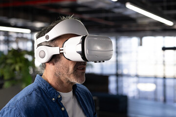 Middle-aged man experiencing virtual reality demonstration in modern office wearing headset