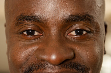 African American man facing camera, gazing indoors, showing eyes nose mustache skin texture