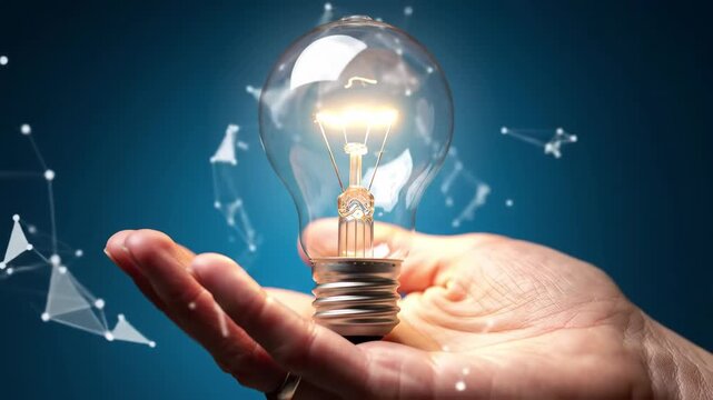 Close-up of an illuminated light bulb being held above a hand, set against a blue backdrop with geometric designs and a bright, conceptual aesthetic.