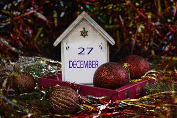 December 27th calendar: the number 27 and the month's name in English on a decorative calendar among Christmas decorations