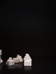 Handcrafted sugar cubes shaped like hearts and other figures, scattered on a dark surface. Ideal for bakery promotions, culinary arts, or Valentine's Day concepts.