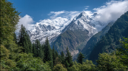 Majestic snow covered mountain peaks rise above lush green trees under a blue sky with scattered clouds in a serene and breathtaking natural landscape view.