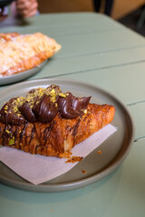 Chocolate topped croissant served on a plate, showcasing artisanal bakery products, caf&eacute; lifestyle, and modern dessert presentation. Publique bakery, popular tourist destination in Melbourne