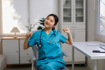 Female healthcare worker in scrubs and stethoscope taking a moment to stretch and relax, avoiding burnout at the office