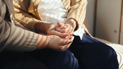 Adult person providing comfort and support, holding elderly person hands. Empathy and love for family