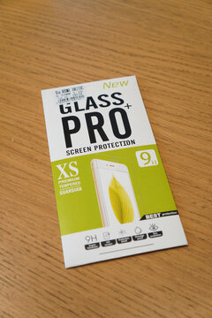 Glass Pro screen protector packaging on a wooden surface, close-up shot