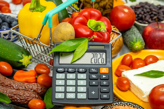 Rising food prices. A grocery basket with food and a calculator with the date 2026. Financial and economic concept. Products becoming more expensive in 2026. Close up