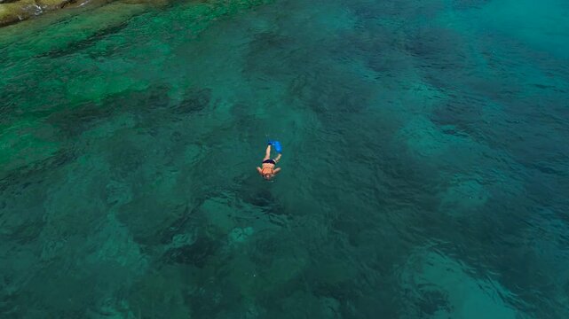 Vacation in Southeast Asia, sea travel in Thailand. Snorkeling near tropical islands. A woman in a mask and fins explores the underwater world off Racha Yai Island.
