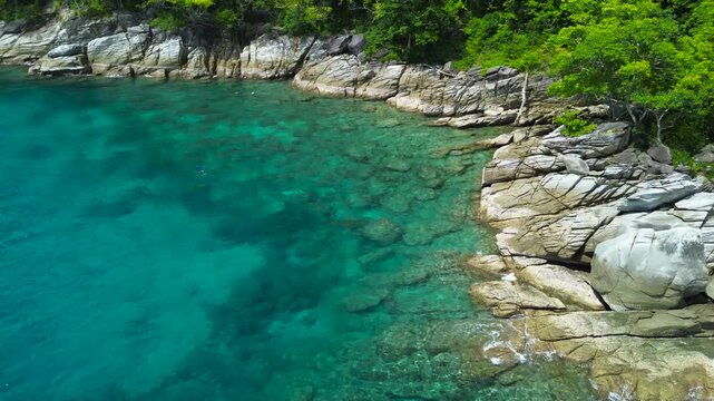 Vacation in Southeast Asia, sea travel in Thailand. Snorkeling near tropical islands. Tourists off the coast of Koh Racha Yai explore the underwater world, as seen from a drone.