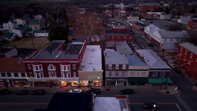 Explore Charles Town aerial, West Virginia as dusk falls, showcasing brightly lit streets adorned with Christmas lights and holiday spirit