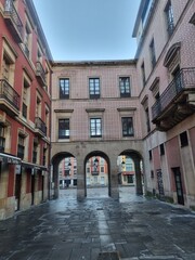 Main square of the tourist city of Gijon with its classic buildings and stone arches surrounding the square, Asturias.
