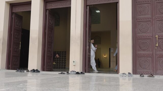 Mosque Entrance with Worshippers and Shoes Left Outside