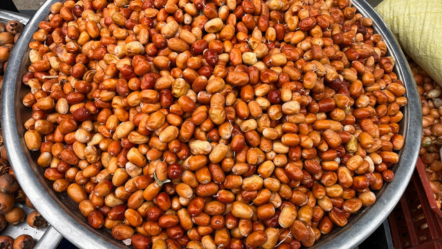 A generous amount of fresh hawthorn berries, ranging in color from orange to red, displayed on a large metal tray. Autumn harvest, natural and local fruit.
