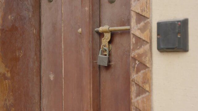 Close Up of Old Wooden Door Locked with Metal Padlock