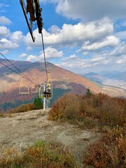 Autumn Mountains and Chairlift in Ukraine; scenic view of an empty yellow chairlift stretching across colorful autumn mountains in Ukraine