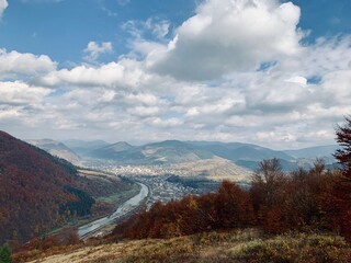 Autumn Valley Landscape with River and Mountain Views, Ukraine; sweeping autumn landscape shows a winding river cutting through a valley surrounded by mountains