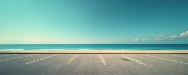 Empty parking lot overlooks calm sandy beach with blue ocean water. Clear sky few white clouds. Serene coastal landscape suggests travel, vacation, freedom by sea shore in summer. Wide, open horizon