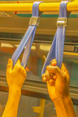 Hands Holding Straps on Bus Rail Showing Urban Travel and Diversity