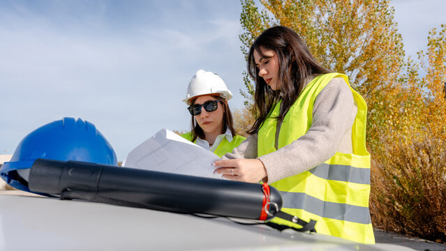 Architect and engineer reviewing blueprints on site