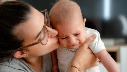 Mother comforting her crying baby in tender embrace
