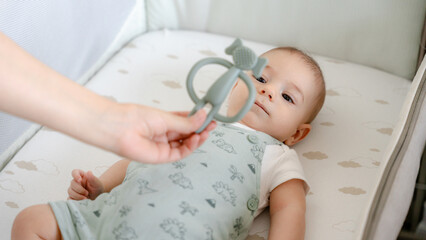 Baby gazing at toy in cozy crib environment