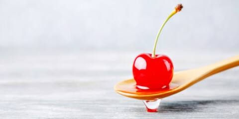 Red cherry with water drop on a wooden spoon, fresh fruit, sweet food, healthy eating, vitamin concept