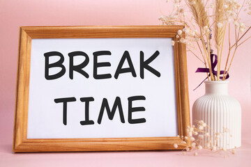 Break Time symbol. Concept words Break Time on beautiful wooden picture frame. Beautiful pink background with flower vase. Business and Break Time concept. Copy space.