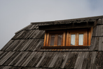 A visually striking shot of an old wooden building, likely traditional or historic, showing dilapidated brown wooden windows.