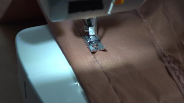 Sewing machine closeup foot sews a stitch on fabric. Machine works video sound. Needle sew thread