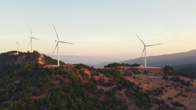 Wind turbines above a mountain valley at first light, aerial. Electricity-mix decarbonization through wind power