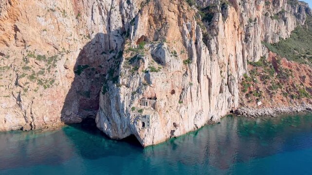  castle nestled on vertical cliffs above serene mediterranean coves near italy. Porto Flavia. 
