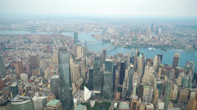 A spectacular aerial view of Lower Manhattan's skyscrapers and iconic landmarks. The Brooklyn and Manhattan Bridges span the East River, connecting the bustling cityscape to Brooklyn.