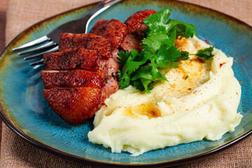 roast duck breast, sliced with mashed potatoes, on a plate,close-up, no people,
